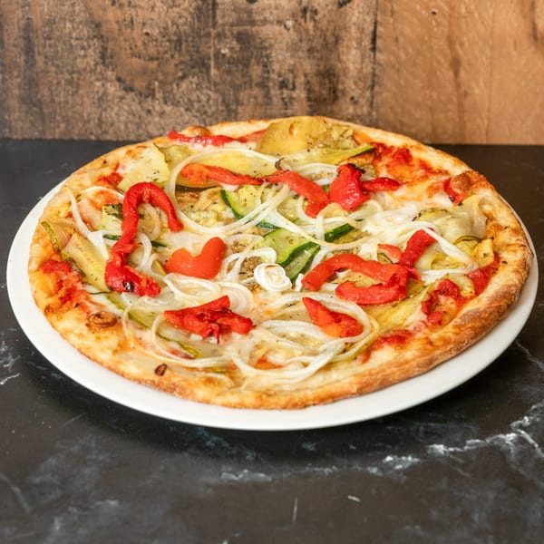 Piccolo Pizza & More's pizza with red peppers, onions, and zucchini on a white plate.
